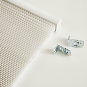 Close-up of dual-core cellular shades featuring honeycomb design for insulation, alongside mounting clips for easy installation.