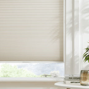 Dual-core cellular shades in a light beige color, providing sound insulation, thermal protection, and a cordless electric option.